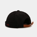 Detail of black corduroy docker cap featuring red embroidery and leather strap closure - Black