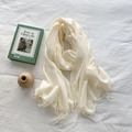 Elegant cream white cashmere-feel scarf with long tassels in a minimalist flat lay - Cream