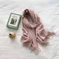 Minimalist pink cashmere-feel scarf with elegant fringes displayed on a soft fabric - Romantic Pink
