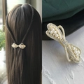 Elegant gold bow hair clip with white pearls and rhinestones shown on model - Flowing Bow Spring Clip