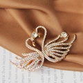 Elegant gold finish twin swan brooch with sparkling rhinestones and crystal details - Gold Double Swan Spring Clip
