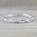 Elegant twisted silver ring with sparkling crystal stones on a natural wood background - US 7 / Silver