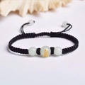 Handwoven black string bracelet featuring a white bead with golden zodiac lion engraving - Black Rope [Monkey]