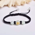 Detail of hand-woven black rope bracelet featuring a luminous bead with golden dragon motif - Black Rope [Dragon]