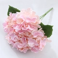 Faux 5-head hydrangea bouquet in pink-orange gradient with green leaves on marble - Golden Pink