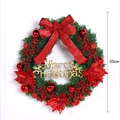 Couronne de Noël 50cm avec fleurs rouges, baies, signe doré et grand nœud rouge - 50cm