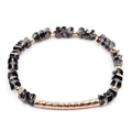 Close-up of faceted dark grey crystal beads and hammer-textured gold tube on a bracelet - Deep Grey