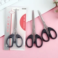 Set of three stainless steel office scissors with black handles on a pink desk background - Carded Small Size
