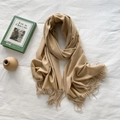 Solid khaki cashmere-feel scarf with fringe tassels laid on white fabric background - Beige