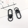 Deux mousquetons en forme de cœur noir en métal avec anneaux rotatifs sur fond blanc - Porte-clés / Noir mat