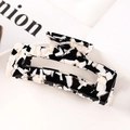 Detail of large acetate hair claw clip featuring black and white marble pattern design - S118-13 Cow Pattern