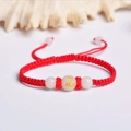 Detail of red woven bracelet with a luminous white bead featuring a golden snake pattern - Red Rope [Snake]
