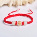 Close-up of handmade red string bracelet with glowing beads and golden zodiac tiger charm - Red Rope [Tiger]