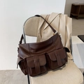 Grand sac cabas marron en similicuir vintage avec poches sur un blazer beige - Marron