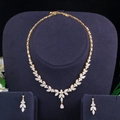Close-up of golden necklace and earring set with white AAA cubic zirconia in floral design - Gold Color