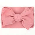 Close-up of wide dusty rose baby headband with textured bubble fabric and large bow - Pink