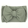 Detailed close-up of sage green baby headband with large bow and ribbed fabric texture - Bean Green