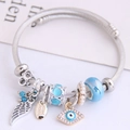 Zilveren kralenarmband met boze oog en engelenvleugel bedeltjes met blauwe glaskralen - Meerblauw