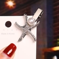 Silver starfish hair clip featuring a white pearl detail and metallic texture - Starfish Pearl / Silver