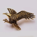 Eagle shaped ring with gold finish and black detailed wings on white background - Eagle
