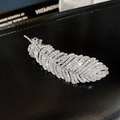 Elegante zilveren veren haarclip met sprankelende witte steentjes op zwarte achtergrond - Zilver