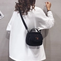 Simpatica borsa a tracolla in lana d'agnello nera con ricamo a orsetto indossata da modella - Nero