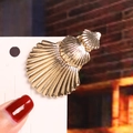 Golden shell hair clip with triple-layered marine design on white card display - Three Shells / Gold