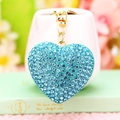 Macro shot of a blue heart keychain with sparkling rhinestones and a gold metal ring - Blue Rhinestone Heart