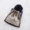 Golden and black knit beanie with pompom on plush white background for winter warmth - One Size / Gold