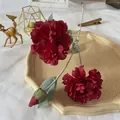 Detail of silk peony petals and buds in dark red with realistic leaf texture on stem - Red