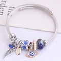 Verstelbare zilveren gedraaide draadarmband met blauwe evil eye en veerhangertje - Blauw