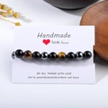 Detailed shot of tiger eye stone and sandalwood beaded bracelet on a white display card - 10mm B0243