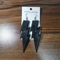 Fashionable black glitter lightning bolt earrings displayed on card packaging - Black