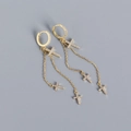 Close-up of golden S925 silver cross earrings with shimmering tassel charms and tiny diamonds - Yellow Gold Color (Pair)