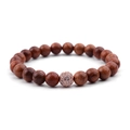 Makroaufnahme von rotbraunem Holzperlenarmband mit roségoldener Pavé-Zirkon-Akzentperle - Rotes Holz & Zirkonia-Ball