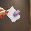 Gros plan d'une barrette ovale violette en résine avec un motif de chat doré élégant - Violet