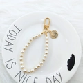 Detail of elegant pearl keychain with golden coin pendant and portrait embossing - Round Queen Relief Style (3087-2)