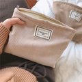 Detailed close-up of warm beige corduroy cosmetic bags with zipper and Time to Party label - Beige