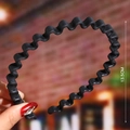 Detail shot of a black wave-shaped matte plastic headband showing 13.5cm diameter size - Black (Wave Matte)