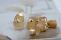 Detailed close-up of natural raw citrine stone pendant with gold plated metal edge - Citrine