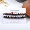 Detailed shot of handmade tiger eye stone and sandalwood bead bracelets on white card - 8mm+8mm Set of 2 B0244