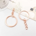 Llavero de metal oro rosa con anillo dividido y cadena corta sobre fondo decorativo - 30MM / Con Cadena / Oro rosa