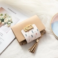 Cartera pequeña beige con flores, cierre de hoja metálica y detalle de borla suave - Beige