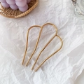 Épingle à cheveux cœur minimaliste en métal doré sur fond de papier blanc froissé - Doré