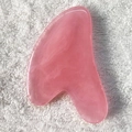 Pink resin heart-shaped Gua Sha tool for face and body massage on white towel - Pink Heart