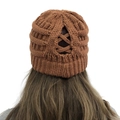 Detail view of brown knit beanie featuring a functional crisscross ponytail hole opening - One Size / Caramel color