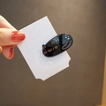 Barrette chat noire en acétate avec détails dorés sur carte de présentation - Noir