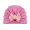 Pink knitted baby turban hat with light pink velvet bow decoration on white background - Pink