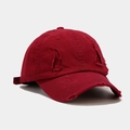 Close-up of distressed vintage dark red cotton baseball cap with ripped hole details - Burgundy