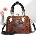 Detail of brown crocodile pattern handbag featuring a luxury crystal clasp and round handles - Khaki/Earth Yellow